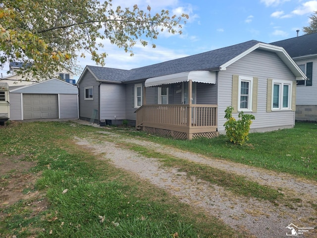 single story home featuring a garage, a front lawn, and an outdoor structure