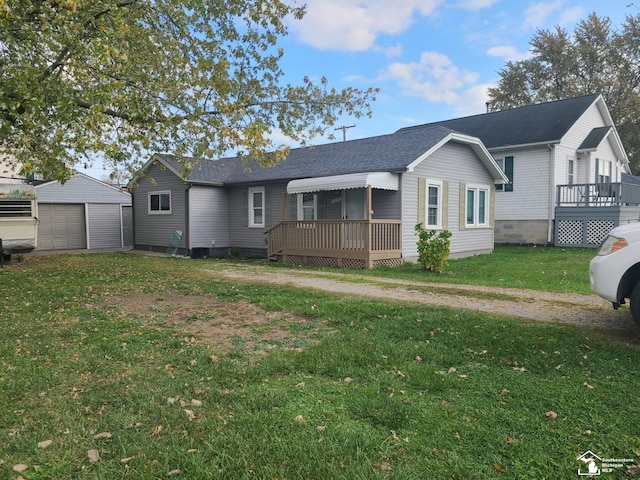 view of front of property featuring a front yard, an outbuilding, a wooden deck, and a garage