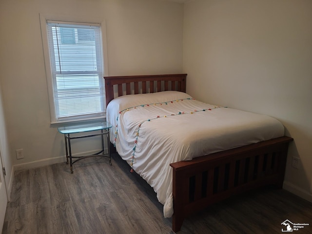 bedroom with dark hardwood / wood-style flooring