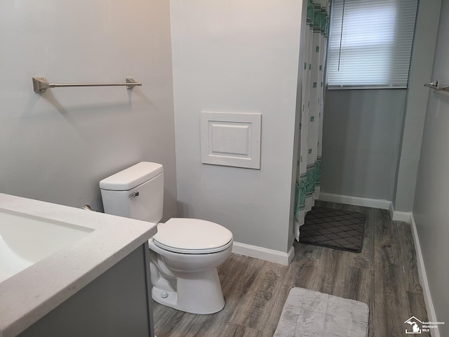 bathroom with hardwood / wood-style floors, vanity, and toilet