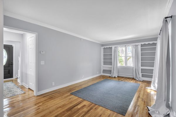 spare room with crown molding and wood-type flooring