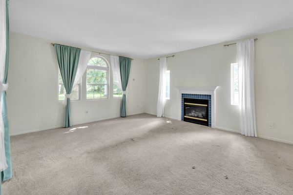 unfurnished living room featuring light carpet and a tile fireplace