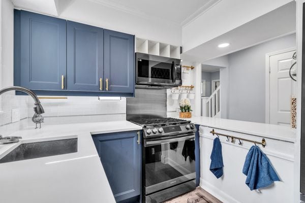 kitchen featuring sink, blue cabinets, and appliances with stainless steel finishes