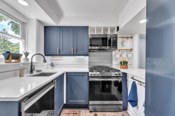 kitchen with blue cabinetry, stainless steel appliances, and sink