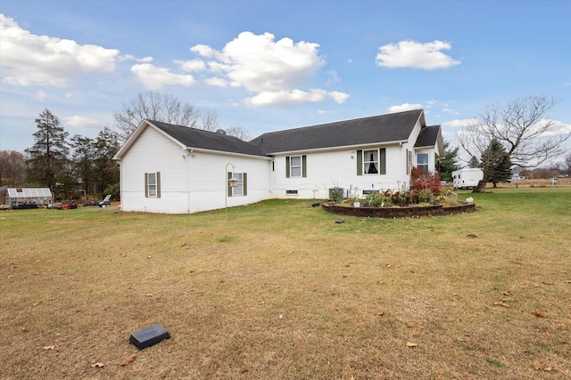 back of house with central air condition unit and a lawn