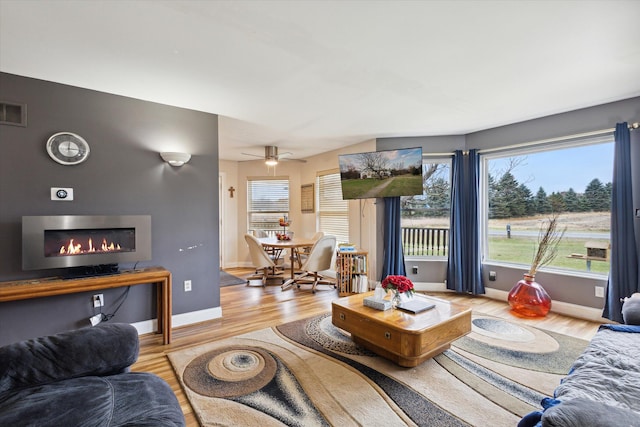 living room with light wood-type flooring and ceiling fan