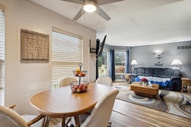 dining space featuring wood-type flooring and ceiling fan