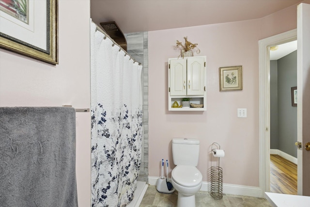 bathroom featuring a shower with shower curtain, toilet, and hardwood / wood-style floors