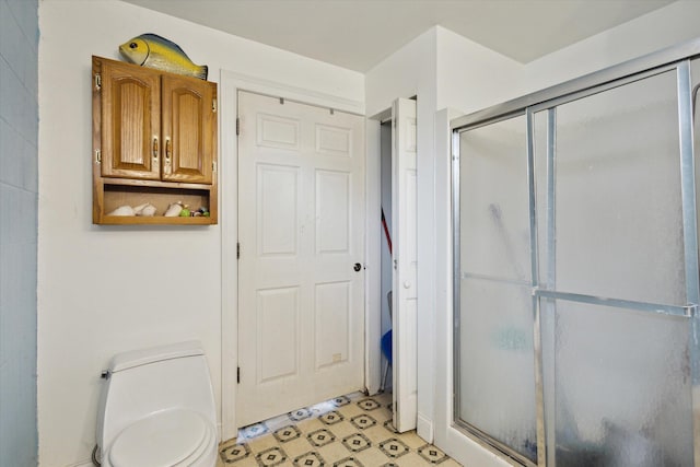 bathroom featuring an enclosed shower and toilet