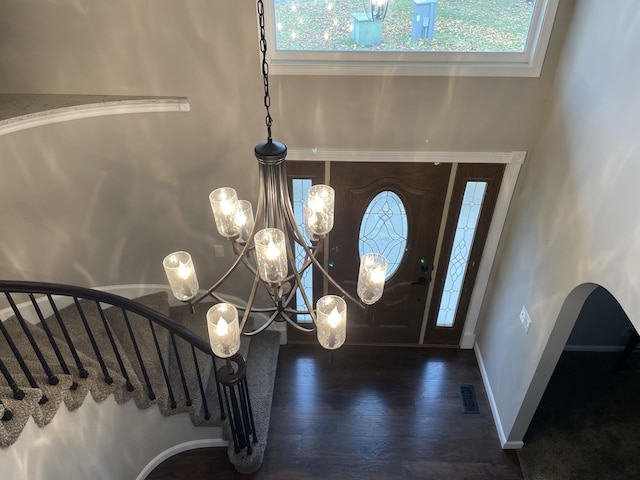 entryway featuring dark hardwood / wood-style flooring, a wealth of natural light, and a notable chandelier