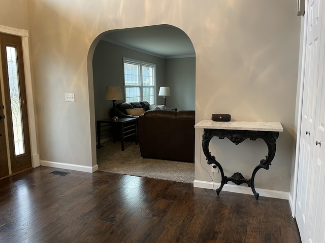 foyer with dark hardwood / wood-style flooring and crown molding