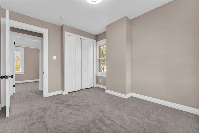 unfurnished bedroom featuring light carpet and a closet