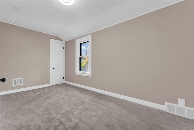 carpeted spare room with lofted ceiling and ornamental molding