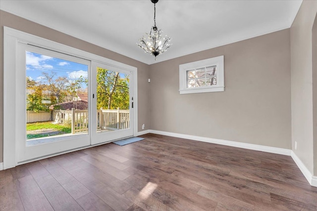 unfurnished dining area featuring dark hardwood / wood-style flooring and a chandelier