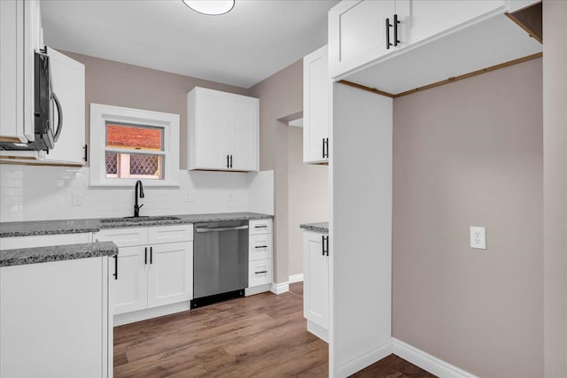 kitchen with white cabinets, dark hardwood / wood-style floors, stainless steel dishwasher, and sink