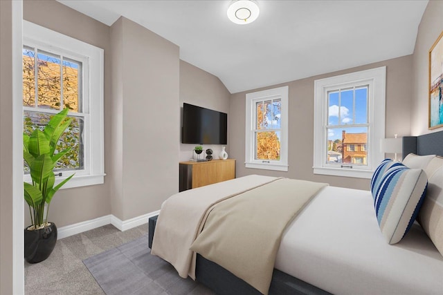 bedroom featuring multiple windows, vaulted ceiling, and carpet floors