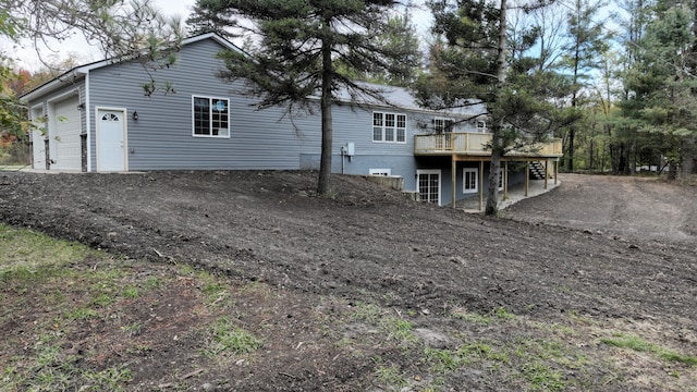 back of property with a wooden deck and a garage