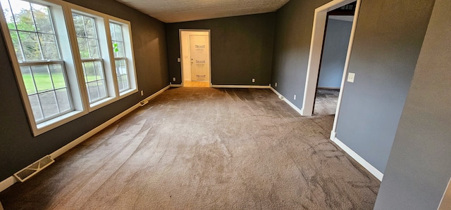 carpeted empty room featuring lofted ceiling and a textured ceiling