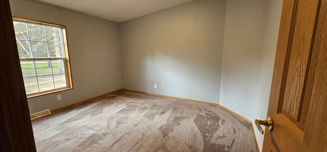 unfurnished room with a textured ceiling and light carpet