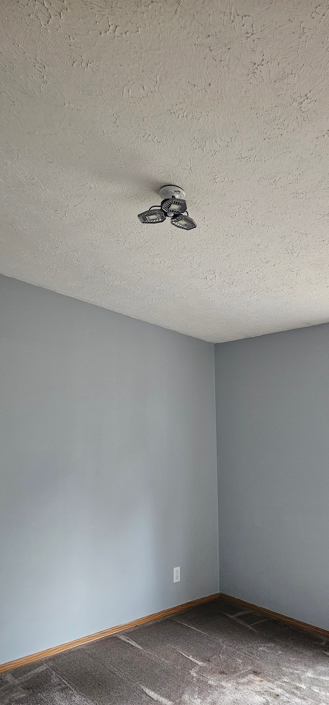 spare room featuring carpet and a textured ceiling