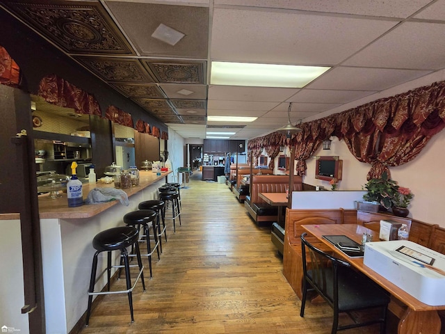 interior space featuring a paneled ceiling and wood-type flooring