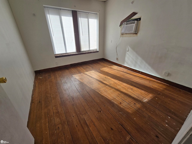 unfurnished room featuring a wall mounted air conditioner and dark wood-type flooring