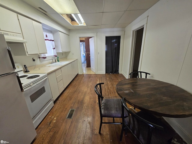 kitchen featuring stainless steel fridge, white cabinetry, electric range, and dark wood-type flooring