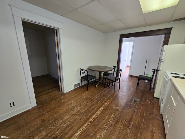 dining space with a paneled ceiling and dark hardwood / wood-style floors