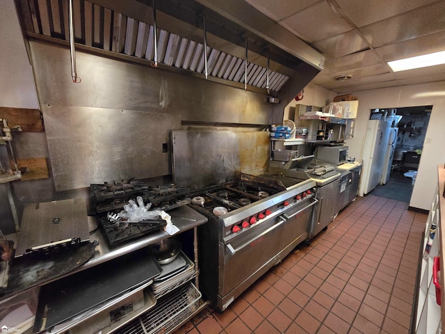 kitchen featuring a paneled ceiling, appliances with stainless steel finishes, and dark tile patterned flooring