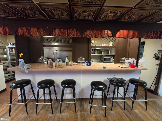 kitchen featuring a breakfast bar and hardwood / wood-style floors