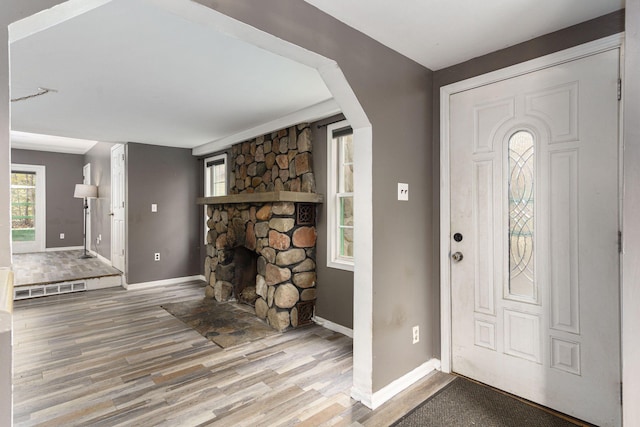 entryway featuring wood-type flooring and a fireplace