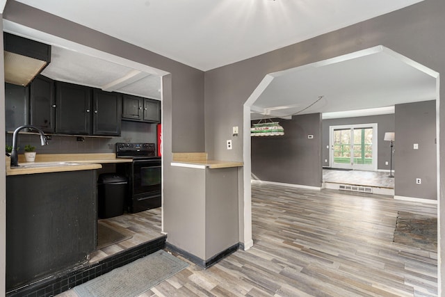 kitchen featuring sink, light wood-type flooring, and black range with electric cooktop