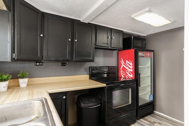 kitchen featuring light wood-type flooring, backsplash, a textured ceiling, sink, and black appliances