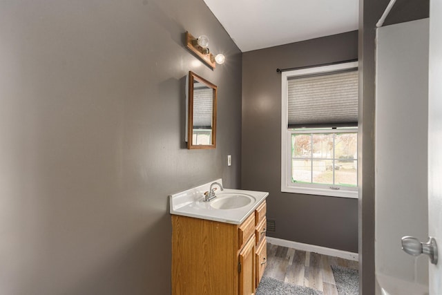 bathroom featuring baseboards, wood finished floors, and vanity