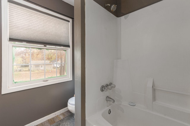 bathroom with toilet, shower / tub combination, and wood-type flooring