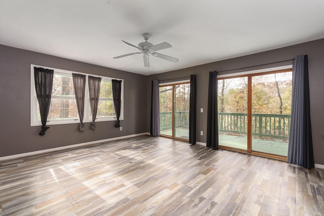 unfurnished room featuring ceiling fan, wood finished floors, and baseboards