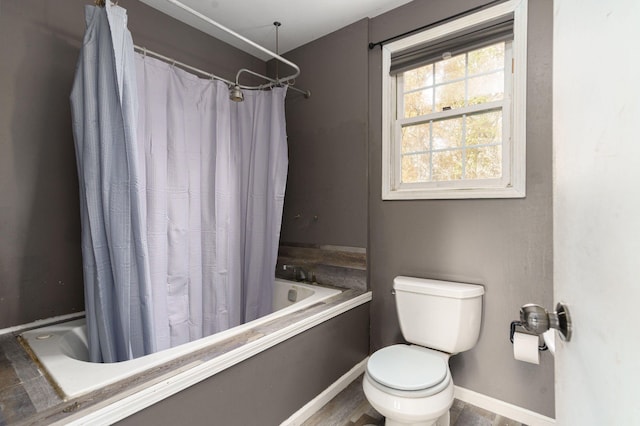 full bathroom with toilet, baseboards, and shower / bath combination with curtain