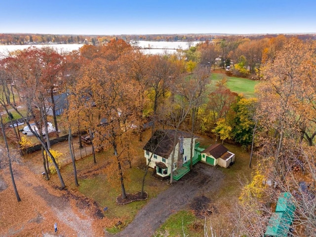 birds eye view of property featuring a water view and a wooded view