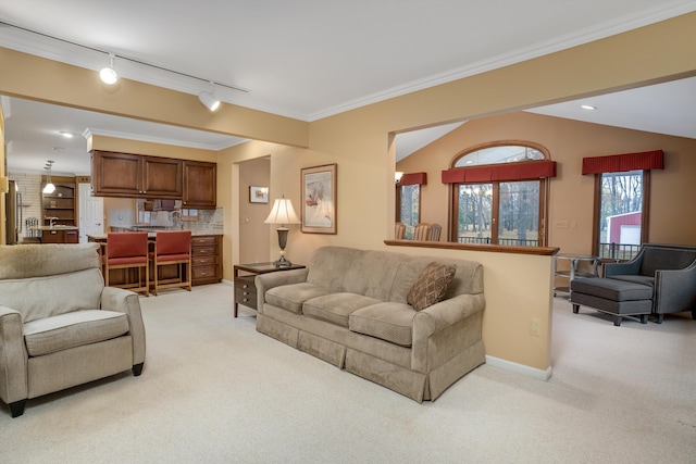 living room featuring light colored carpet, lofted ceiling, ornamental molding, and track lighting