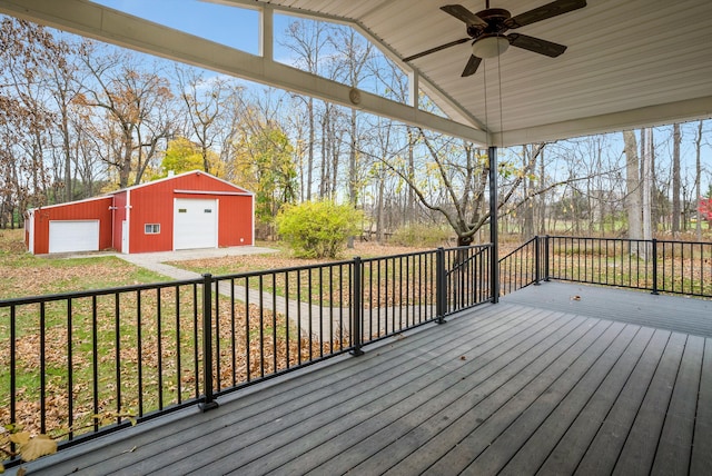 deck featuring ceiling fan, an outbuilding, and a garage