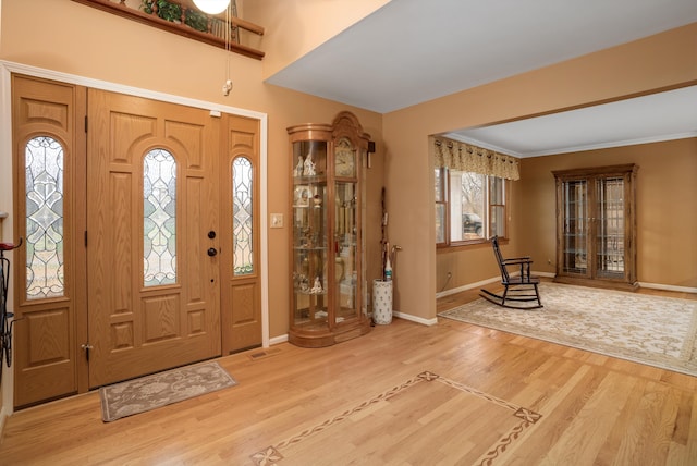 foyer entrance with hardwood / wood-style flooring and ornamental molding