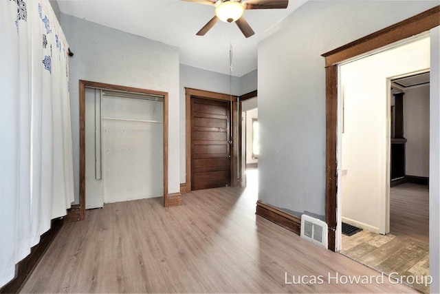 unfurnished bedroom featuring ceiling fan, light hardwood / wood-style floors, and a closet