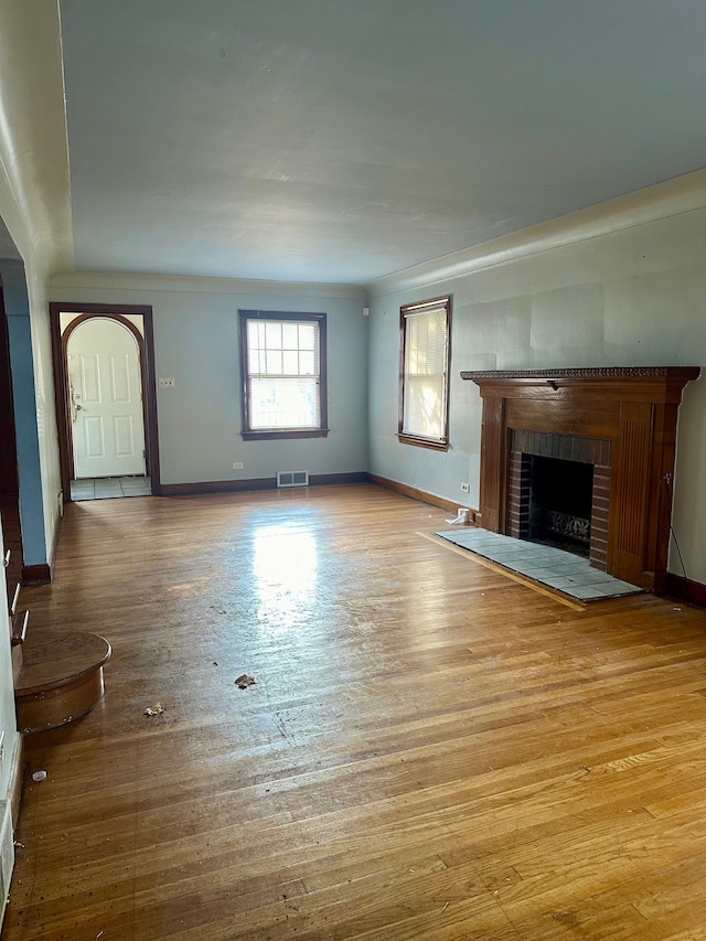 unfurnished living room with a fireplace and light hardwood / wood-style floors