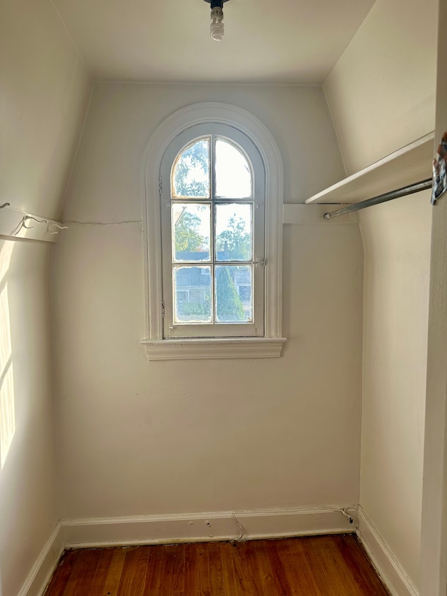 walk in closet with dark hardwood / wood-style flooring and vaulted ceiling