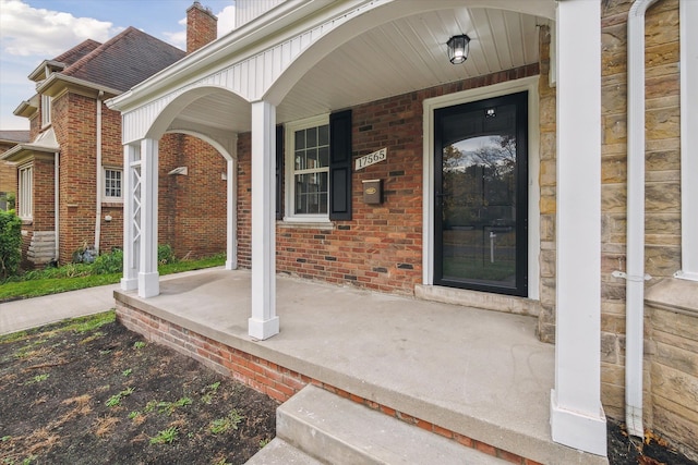 view of exterior entry featuring covered porch