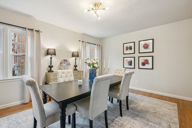 dining space featuring hardwood / wood-style floors, a healthy amount of sunlight, and a chandelier