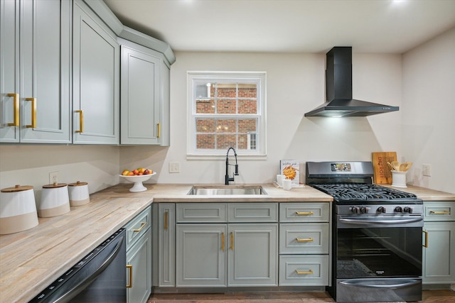 kitchen featuring gray cabinetry, dark wood-type flooring, sink, wall chimney exhaust hood, and stainless steel appliances