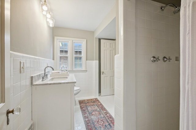 bathroom featuring vanity, tile patterned floors, toilet, tile walls, and walk in shower