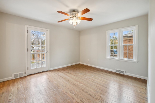 spare room featuring light wood-type flooring, ceiling fan, and a healthy amount of sunlight