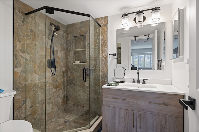 bathroom featuring vanity, toilet, and an enclosed shower